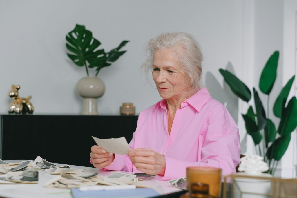 Memory Care Facilities: How to Choose the Best Option for Your Loved One Elderly woman enjoying memories through old photographs, indoors setting.